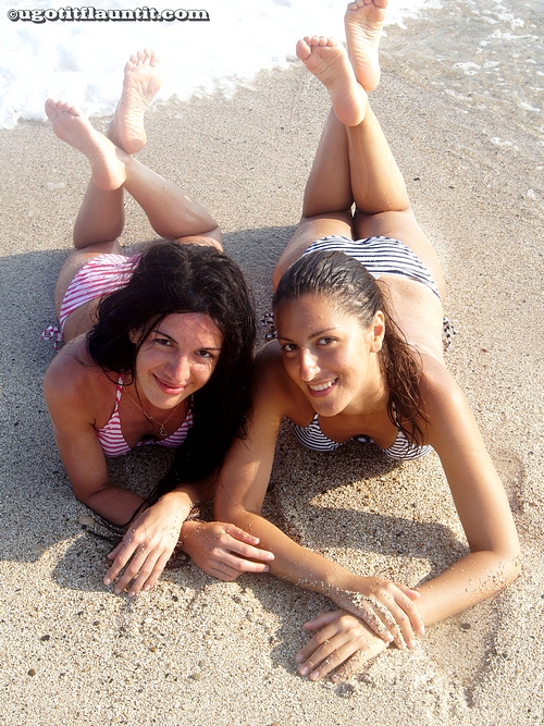 Lucia and Vika are Lying Down on the Beach in the Bikinis