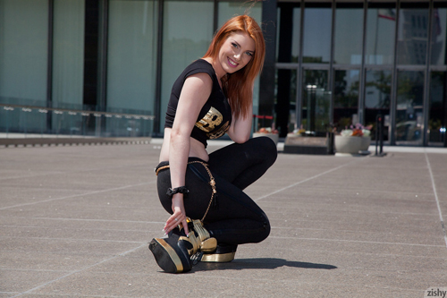 Red-head Lilith Lust looking sexy outdoors