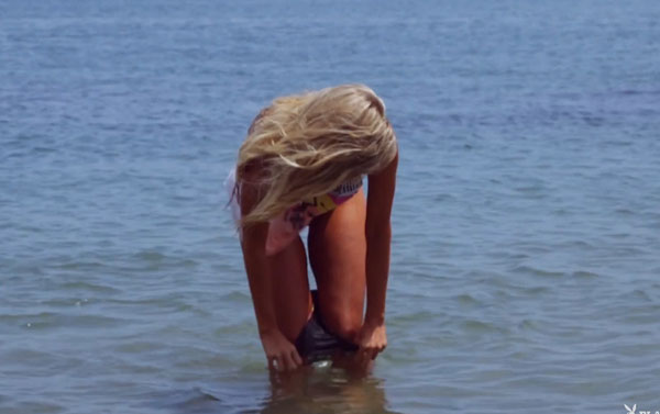 Girl pulling down her bikini bottoms in the sea