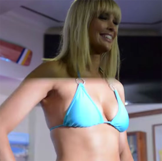 Cute blonde girl smiles as she poses on stage for a bikini competition