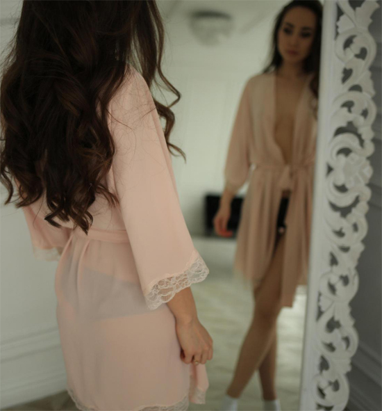 StasyQ brunette is looking at herself in the mirror