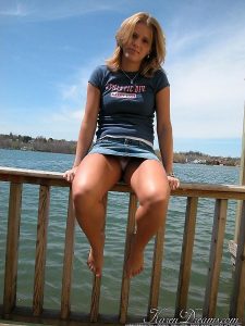 Karen Dreams shows upskirt while sitting on a wooden fence by the lake