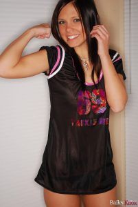 Bailey Knox flexing her muscles in a cheeky black nightgown