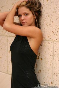 She gives a nice pose with her back against the wall