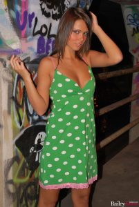 Bailey Knox looking sexy in her green dress surrounded by graffiti