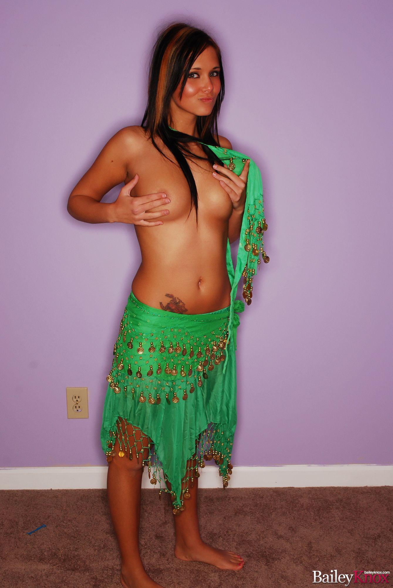 Standing touching her nipples with her fingers