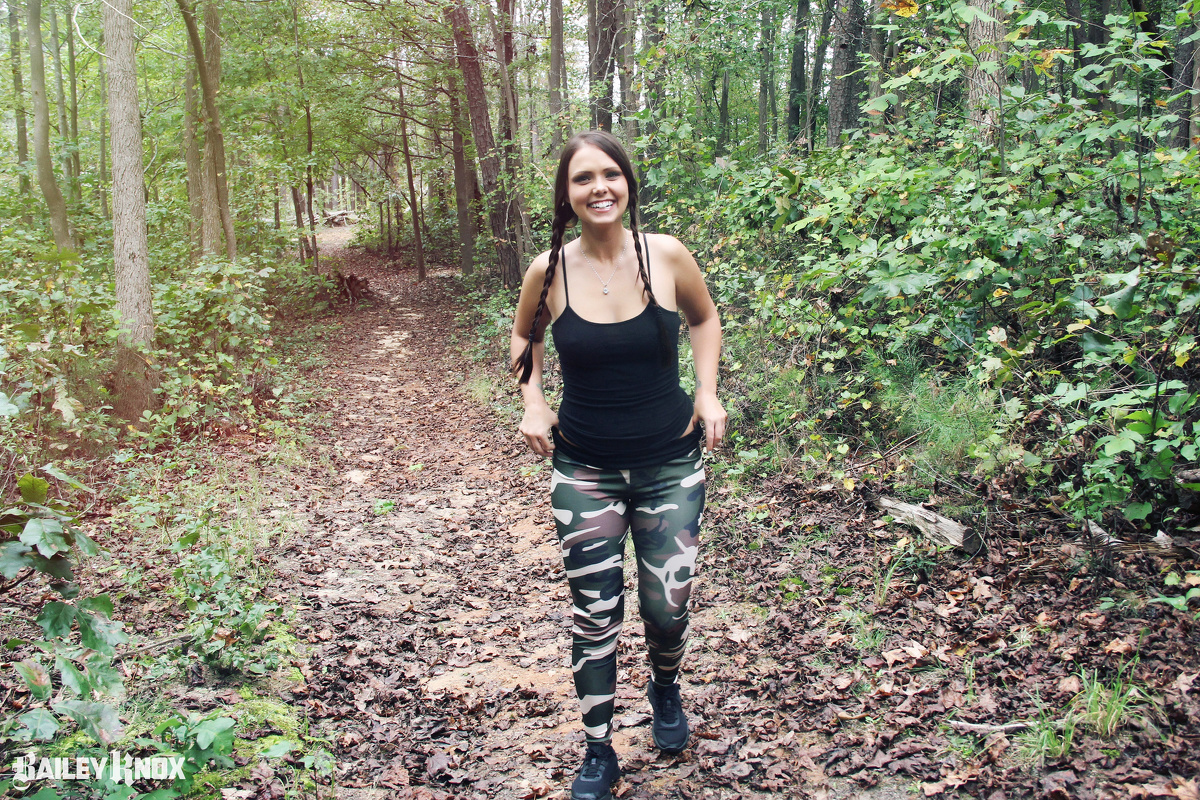 Smiling Bailey Knox having a nice stroll in the woods in her camouflaged leggings