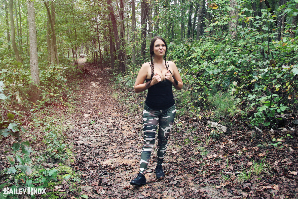 Sexy Bailey Knox squeezing her boobs together in the woods