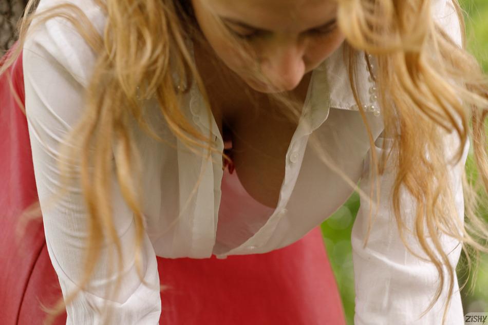Blonde girl leaning froward to give a nice downblouse view