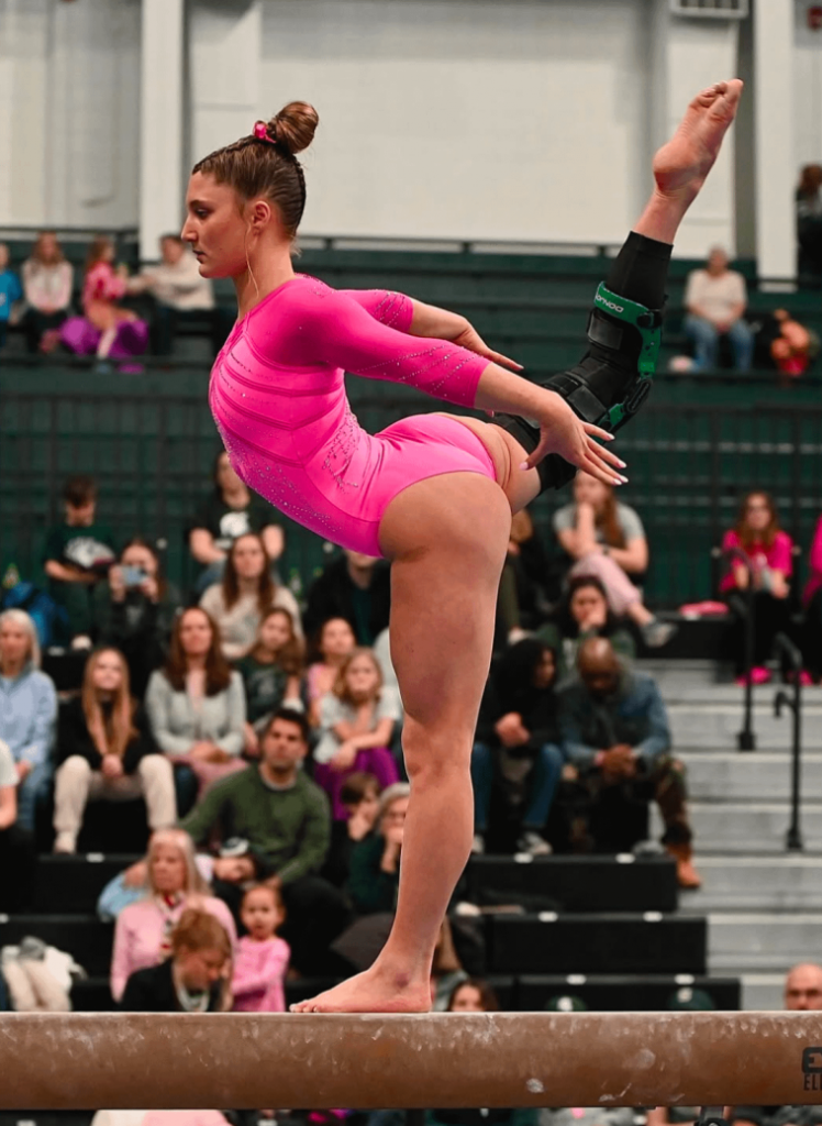 Flexible coed in a pink leotard
